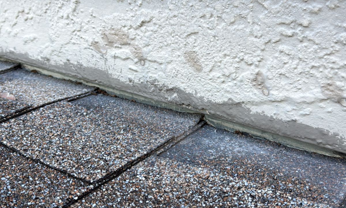 Inspection photo: Roof-to-wall flashing, cracked caulking